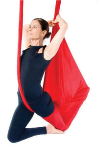 Kırmızı antigravity yoga hamakta poz yapan kadın